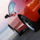 A modern sports car parked at the beach around sunset.