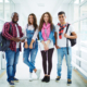 Friendly students in casual-wear standing in college corridor