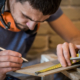 the man makes the measurements on the Board to work with manual electric saw ,close-up , concept building and repair