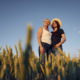 Two women standing on the agriculture field with growing wheat.