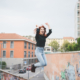 Young handsome caucasian redhead straight hair woman jumping outdoor in the city, hands up, laughing - girl power, goal, success concept