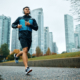 Low angle view of motivated athletic man running during rainy day. Copy space.