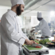 Gastronomy expert preparing garnish for gourmet dish served at restaurant. Head chef chopping fresh and organic red bell pepper in professional kitchen while cooking delicious food.