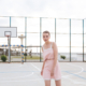 Beautiful tender young woman standing on outdoor playground