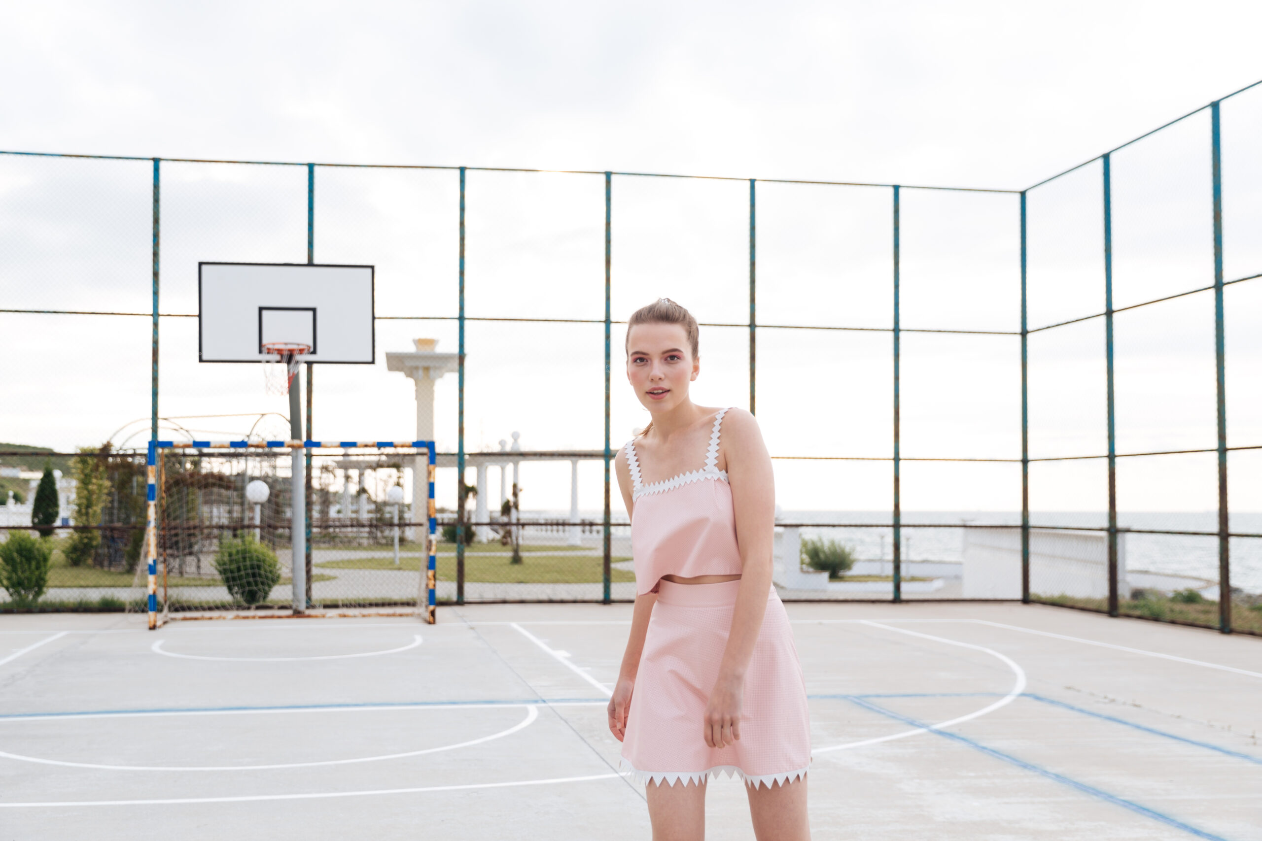 Beautiful tender young woman standing on outdoor playground