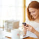 Image of young female reading sms on the phone in cafe