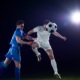 soccer player doing kick with ball on football stadium  field  isolated on black background