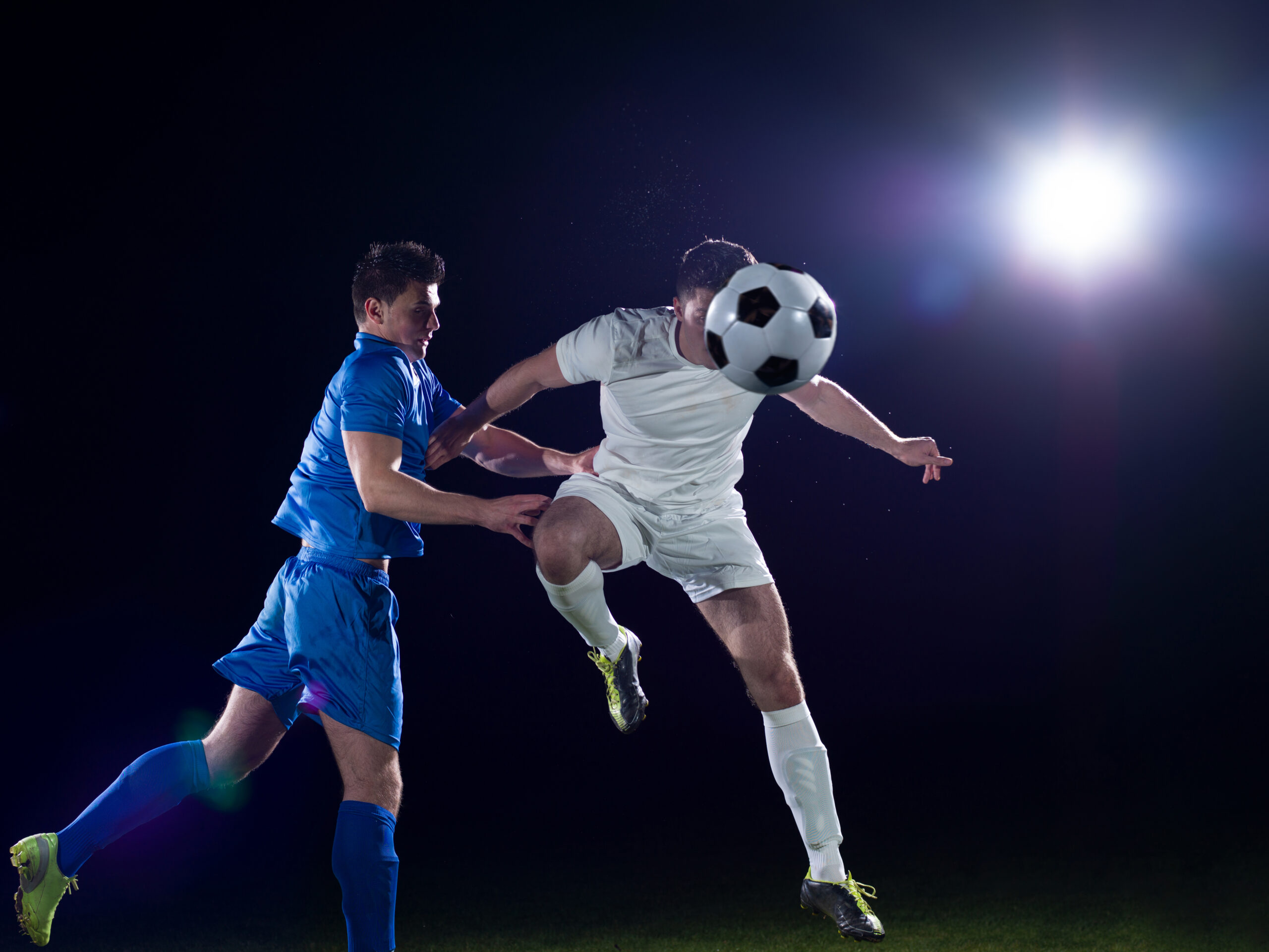 soccer player doing kick with ball on football stadium  field  isolated on black background