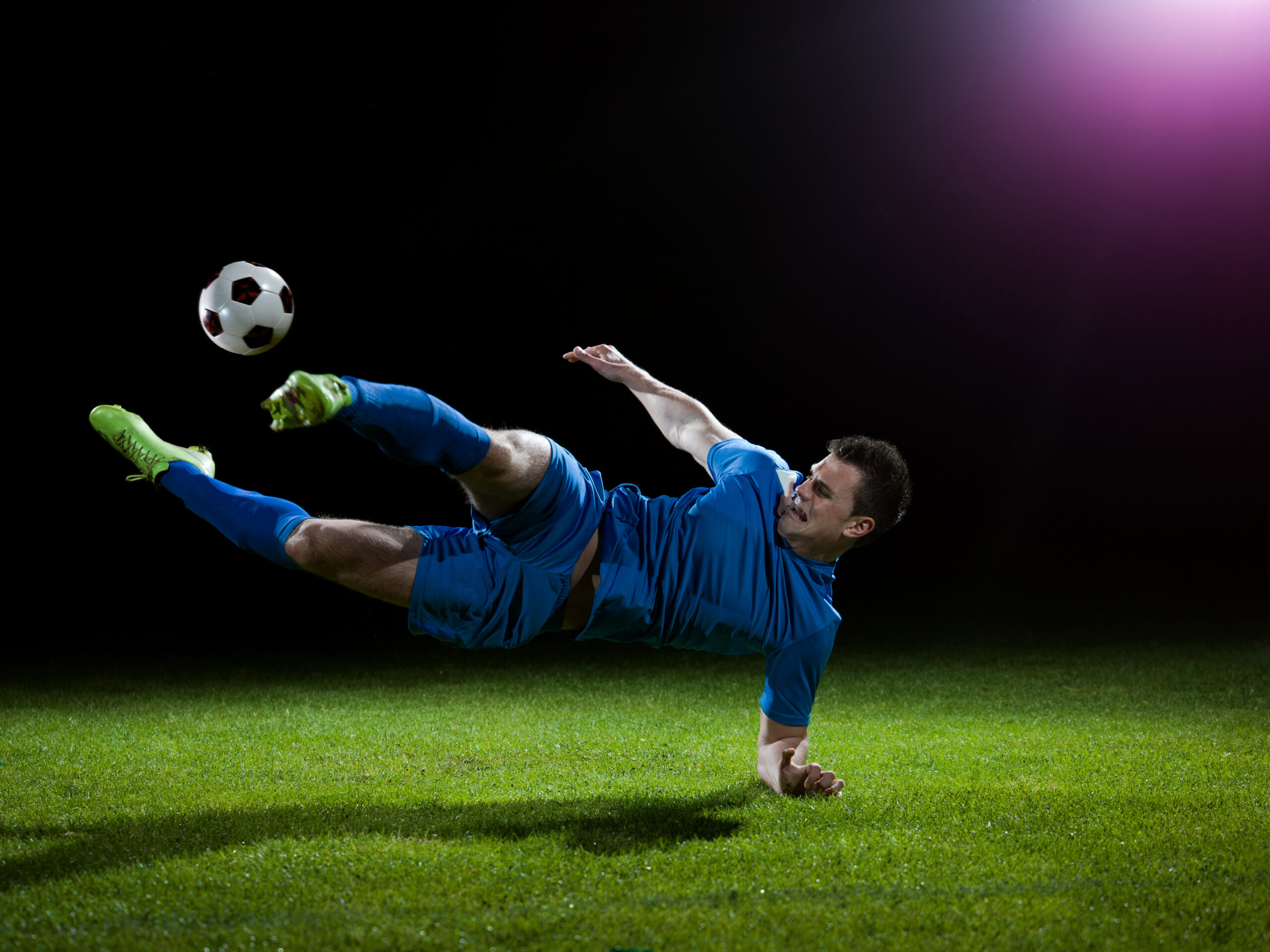 soccer player doing kick with ball on football stadium  field  isolated on black background