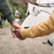 Rear view of unrecognizable children of different ages holding hands while coming in to migrant camp