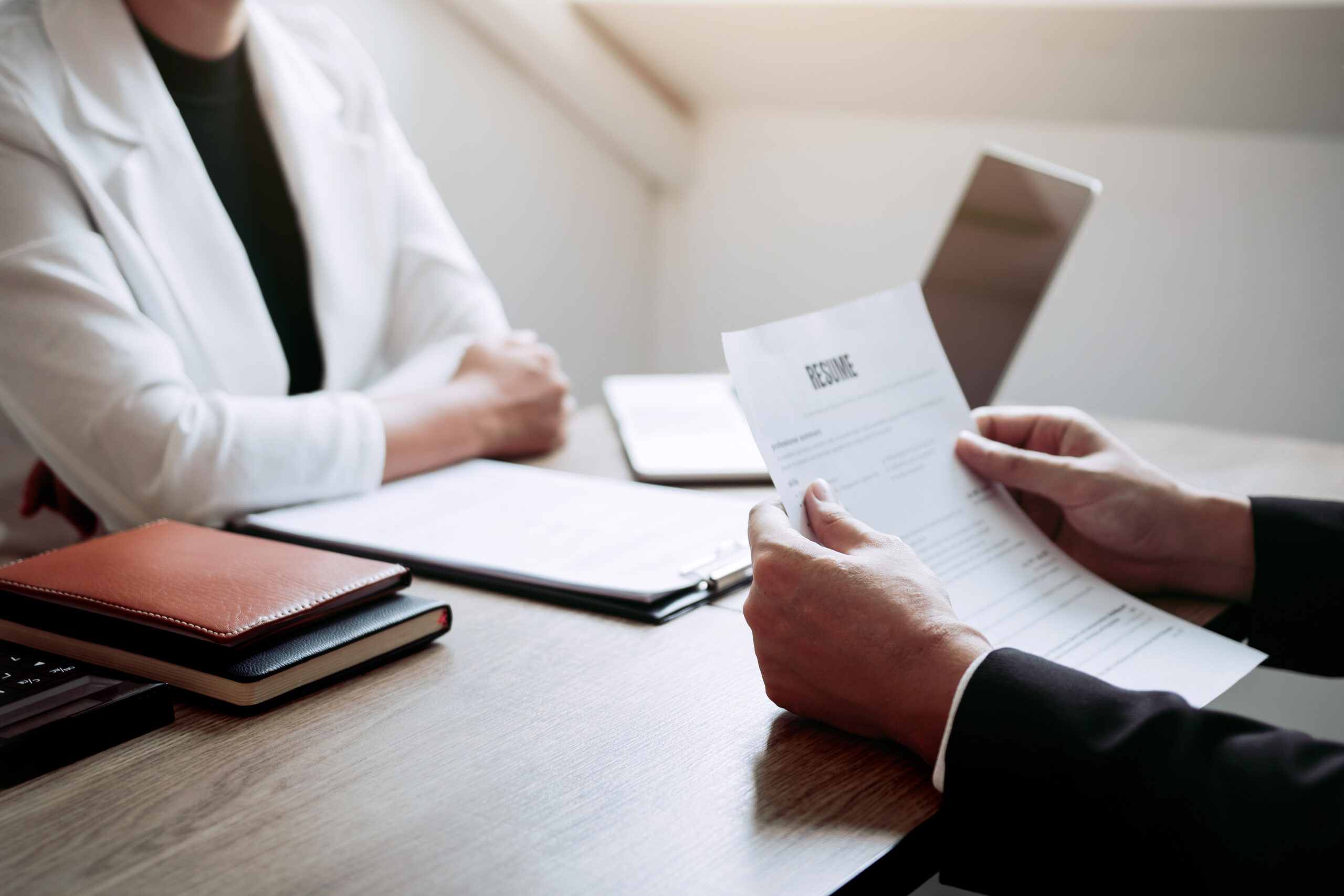 Job applicants are holding a resume document in the job interview room, job interview concept.